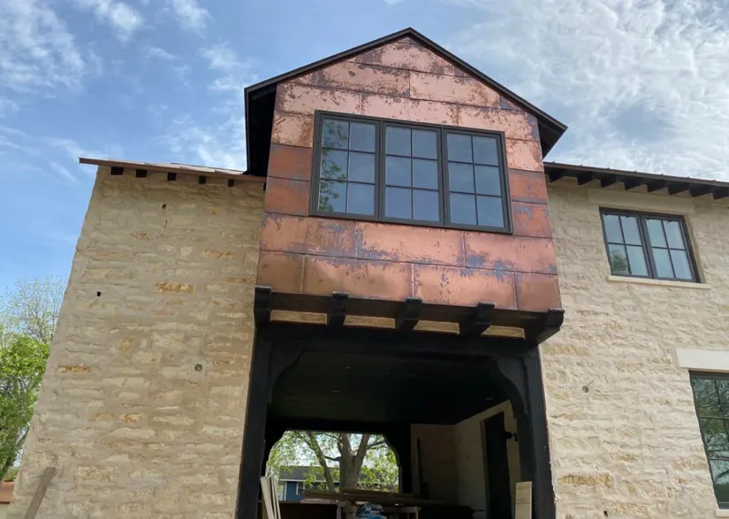 Copper metal panel facade on a stone building for Skylight Installation in Manor